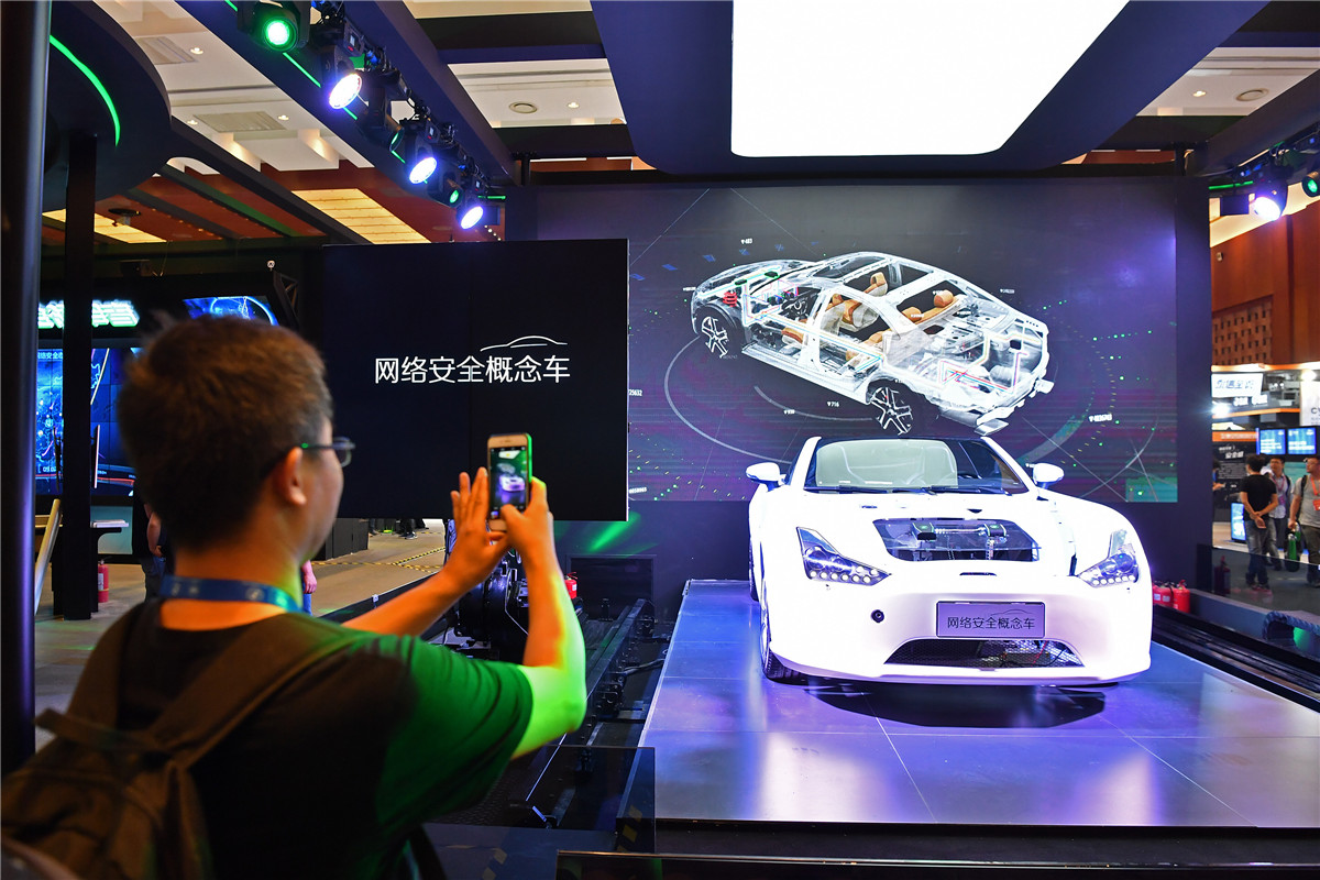 2017中国互联网安全大会在京召开，一名参会者在大会展区拍摄一辆网络安全概念车。 新华社记者李鑫摄影